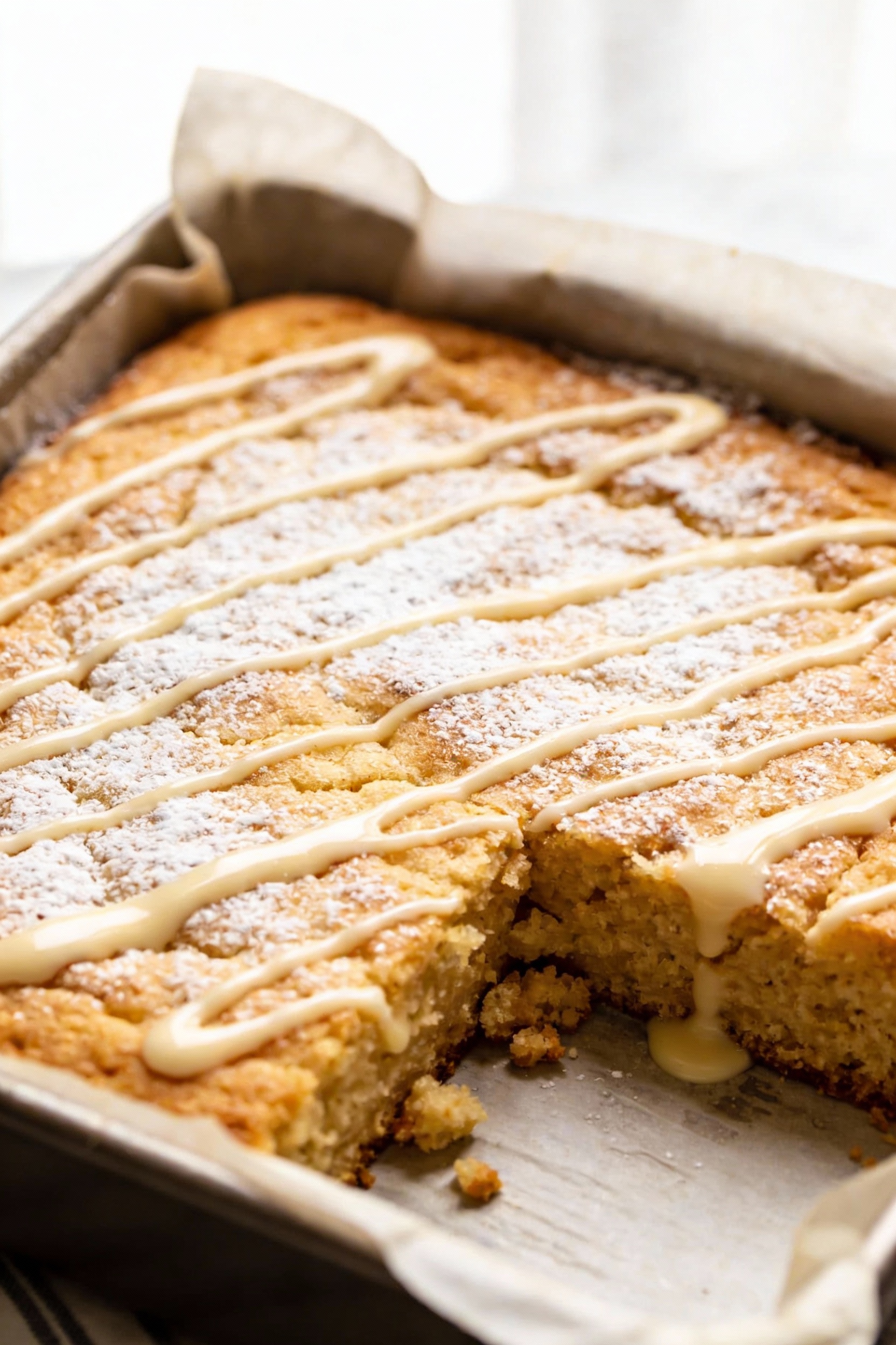 1. Close-up detail of the one-bowl vanilla snack cake in an 8x8 pan, golden tender crumb with a light powdered sugar dus