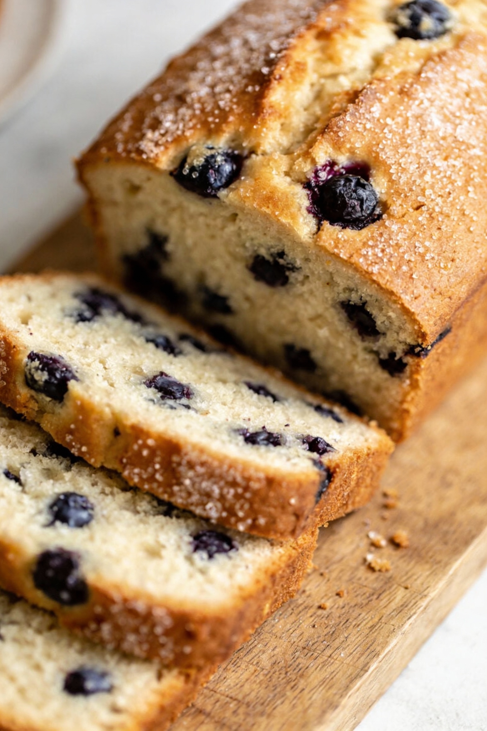 4. Final dish presentation of blueberry buttermilk loaf cut into neat clean slices on a wooden board, tender tight crumb